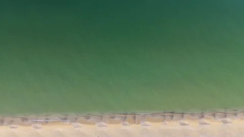 Top Down Aerial View of Turquoise Sea Waves and Sandy Shoreline Stock Footage 325292553