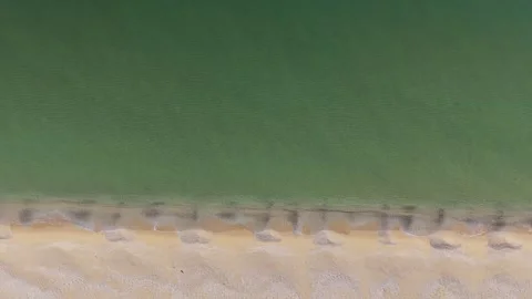 Top Down Aerial View of Turquoise Sea Waves and Sandy Shoreline Stock Footage 325292567