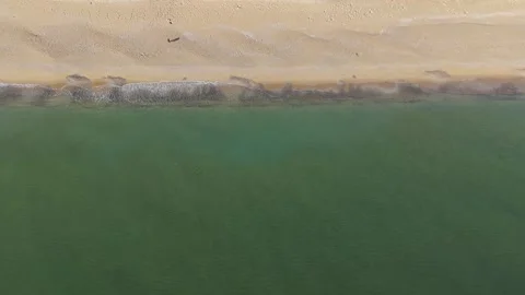 Top Down Aerial View of Turquoise Sea Waves and Sandy Shoreline Stock Footage 325292616
