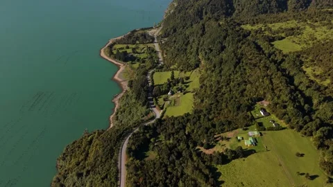 Top-Down Aerial View of Turquoise Fjord and Green Valley with Road 库存影片 334659060