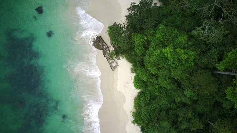 Top-down aerial view of turquoise ocean waves meeting pristine white sand Stock Footage 336797784