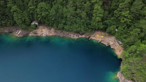 Top down aerial view of turquoise lake shoreline and wooden docks in Chiapas Stock Footage 342285423
