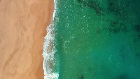 Top down aerial view of turquoise Atlantic wave on empty sandy beach in Portugal Stock Footage 344753348