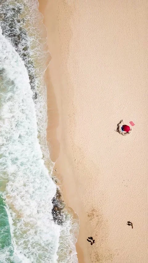 Top-down aerial view of turquoise ocean waves gently crashing onto a sandy Stock Footage 344815775