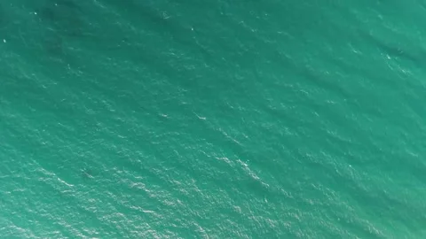 Top down aerial view of turquoise ocean water surface with gentle waves Stock Footage 346168382