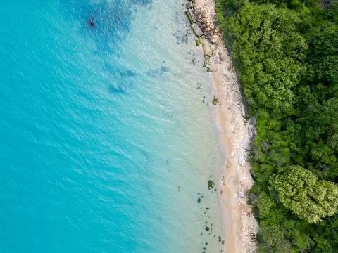 Top Down Aerial View of Turquoise Sea, Rocky Sandy Beach and Forest Stock Photos