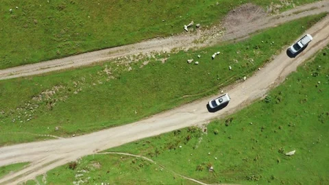 A top-down aerial view of two travelers' cars driving along the dirt mountain 스톡 동영상 163172872