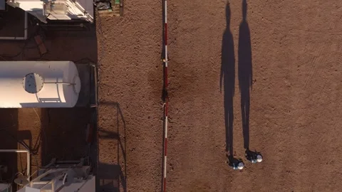 Top down aerial view of two workers walking at oil operations site Stock Footage 329223420