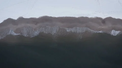 Top down aerial view of waves crashing on the beach in the winter Stockbeeldmateriaal 105550303
