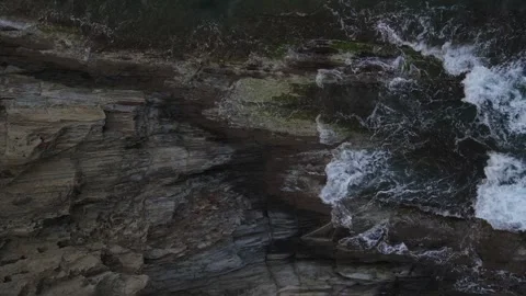 Top down aerial view of waves crashing onto a rock in nature near Cadaques .. 動画素材 244780131