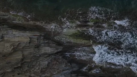 Top down aerial view of waves crashing onto a rock in nature near Cadaques .. 動画素材 244780139
