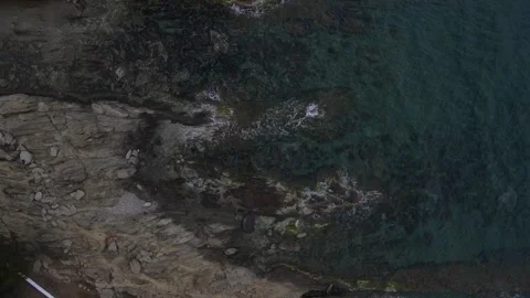 Top down aerial view of waves crashing onto a rock in nature near Cadaques .. 動画素材 244780180