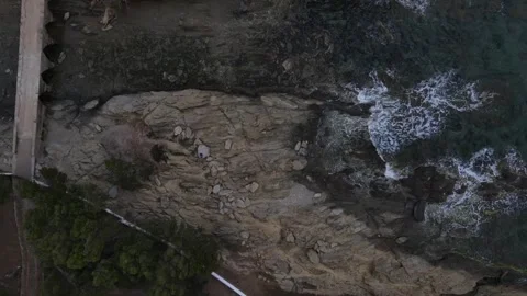 Top down aerial view of waves crashing onto a rock in nature near Cadaques .. 動画素材 244780315