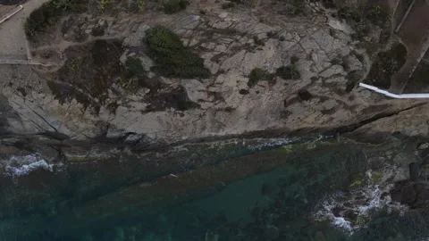 Top down aerial view of waves crashing onto a rock in nature near Cadaques .. 動画素材 244780338