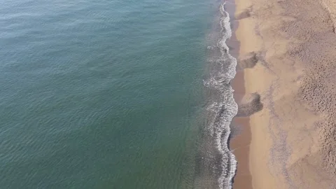 Top Down Aerial View of Waves Meeting Sandy Beach Stock Footage 325292788