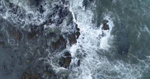 Top down aerial view of waves crashing on rocks the concept of nature's power Video stock 327404792