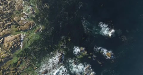 Top down aerial view of waves crashing on granite rocks Stock Footage 327469882