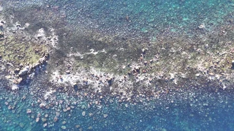 Top Down Aerial View of Waves Crashing over Rocks Video stock 329058900
