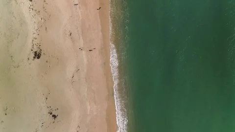 Top down aerial view of waves breaking on sandy beach Stock Footage 329896769