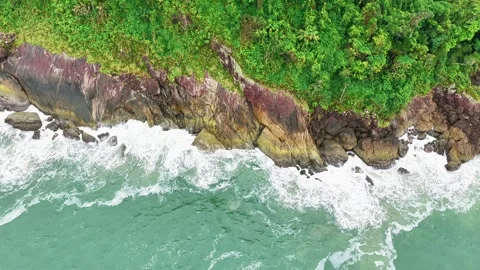 Top-Down Aerial View of Waves Crashing Against Coastal Rocks with White Foam Vídeo Stock 347739022