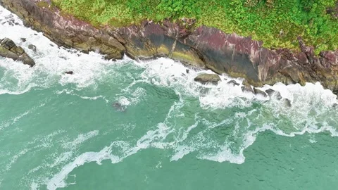 Top-Down Aerial View of Waves Crashing Against Coastal Rocks with White Foam 動画素材 347739023
