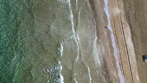 Top-Down Aerial View of Waves Crashing on Golden Sand Beach Shoreline Stock Footage 347747808