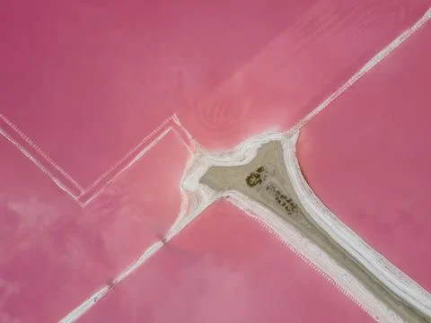 Top down aerial view of white salt formation in pink lake. Stock Photos
