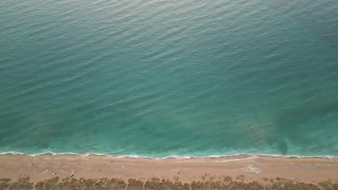 Top-down aerial view of wild beach with turquoise sea and soft waves. Peaceful Stock Footage 317315480