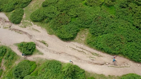 A top-down aerial view of young people walking along a mountain trail to the top Stock Footage 181778837