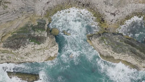 Top Down Aerial of Waves Breaking Over Jurassic Coast Rock Formations Stock Footage 346611423