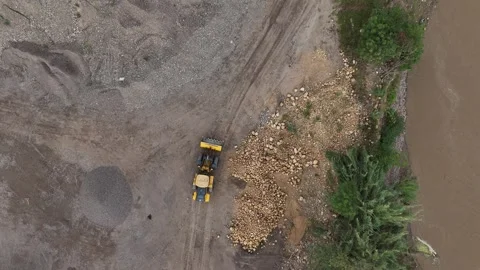 Top down aerial of wheel loader working near muddy riverbank. Stock Footage 340514987
