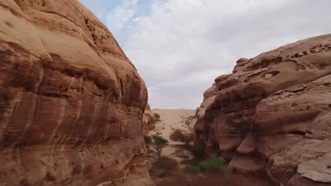 Top down and reveal flying through rock canyons in desert. 4K Aerial Stock Footage 196833711