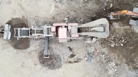 Top Down Ariel Drone Shot of Large Excavator Loading Stone Crushing Machine Stock Footage 194171672