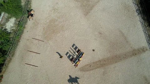 Top down ascending aerial showing trainer gesturing to riders and large Stock Footage 315480042