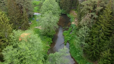 Top-down ascending aerial view of tent camp near small clear river Stock Footage 169925504