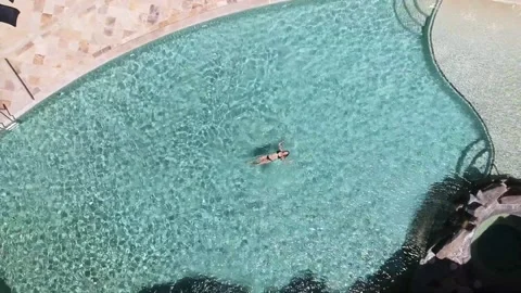 Top down birds eye view drone shot of a girl in a bikini floating in a Stock Footage 149761080