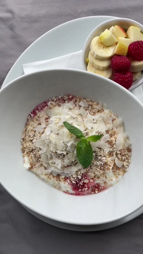 Top down breakfast bowl with yogurt granola coconut flakes mint and berries Stock Footage 341626669