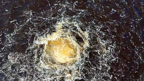 Top-Down Cinematic Drone Shot Capturing a Raging Golden Vortex of Bubbles and Stock Footage 325829145