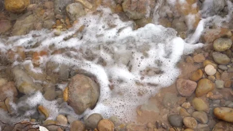 Top-Down Close-Up of Bubbling Clear Water Flowing Over Smooth River Rocks Vídeos de archivo 334182278