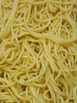 Top-down close-up of cooked yellow egg noodles, textured food background Stock Photos