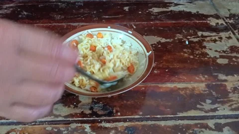 Top-down close-up shot of a person mixing instant noodles and white rice. Stock Footage 321940210