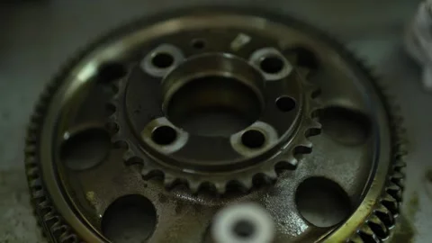 A top-down close-up view displays a large metallic camshaft sprocket gear mec Stock Footage 345109578