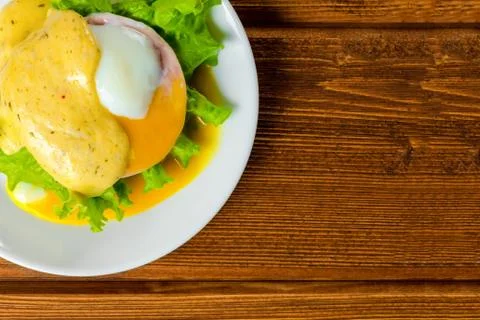 Top down closeup poached eggs, ham, lettuce leaf and delicious buttery fresh  Foto stock