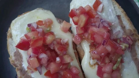 Top-down closeup pull away view of tasty molletes flat bread sandwiches Video stock 325687537