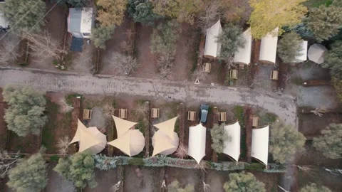 Top down descending aerial view camping canvas tent plot rows in autumn Stock Footage 233162313