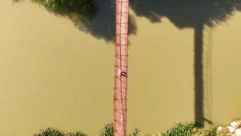 Top Down Descending Drone Shot of Person on Metal Bridge Over Asi River T Stock Footage 336715529