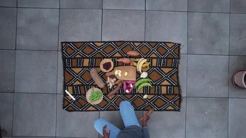 Top down descent over African textile with fresh tropical vegetable and fruit Stock Footage 331030626