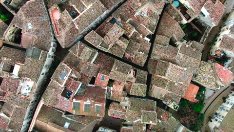 Top-down drone advancing over village rooftops Stockbeeldmateriaal 347585444