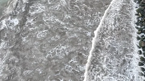 Top Down Drone Aerial View of White Sea Waves Crashing Against Rocky Stock Footage 345953062