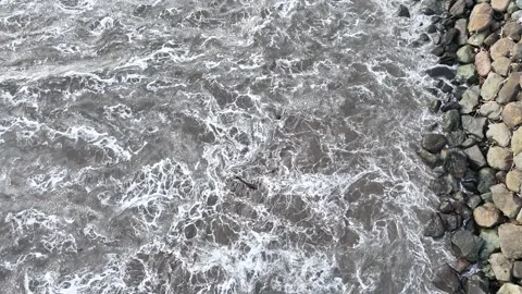Top Down Drone Aerial View of Foamy Sea Waves Splashing on Rocky Stock Footage 345953162